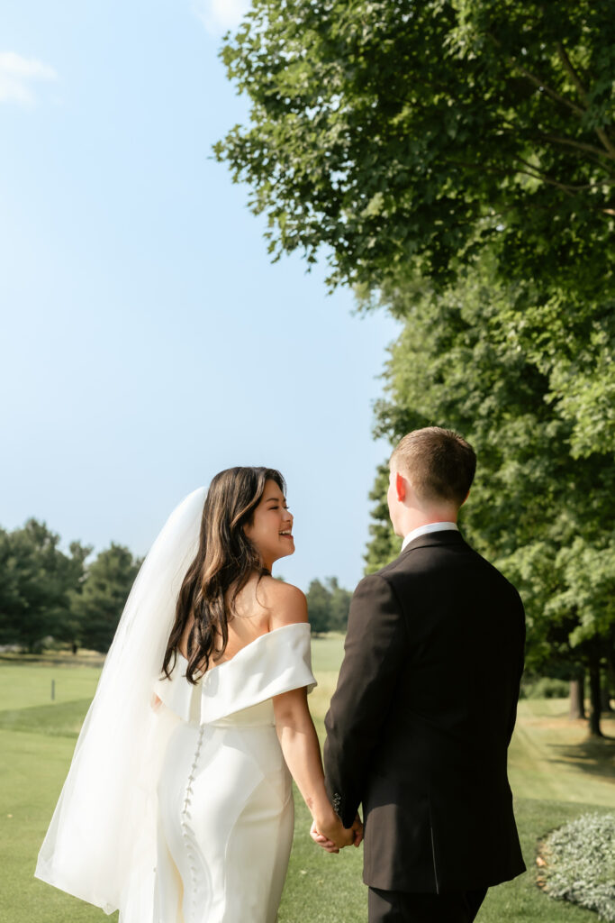 Bride and groom walking through gardens in Copetown warm natural candid Toronto wedding photography